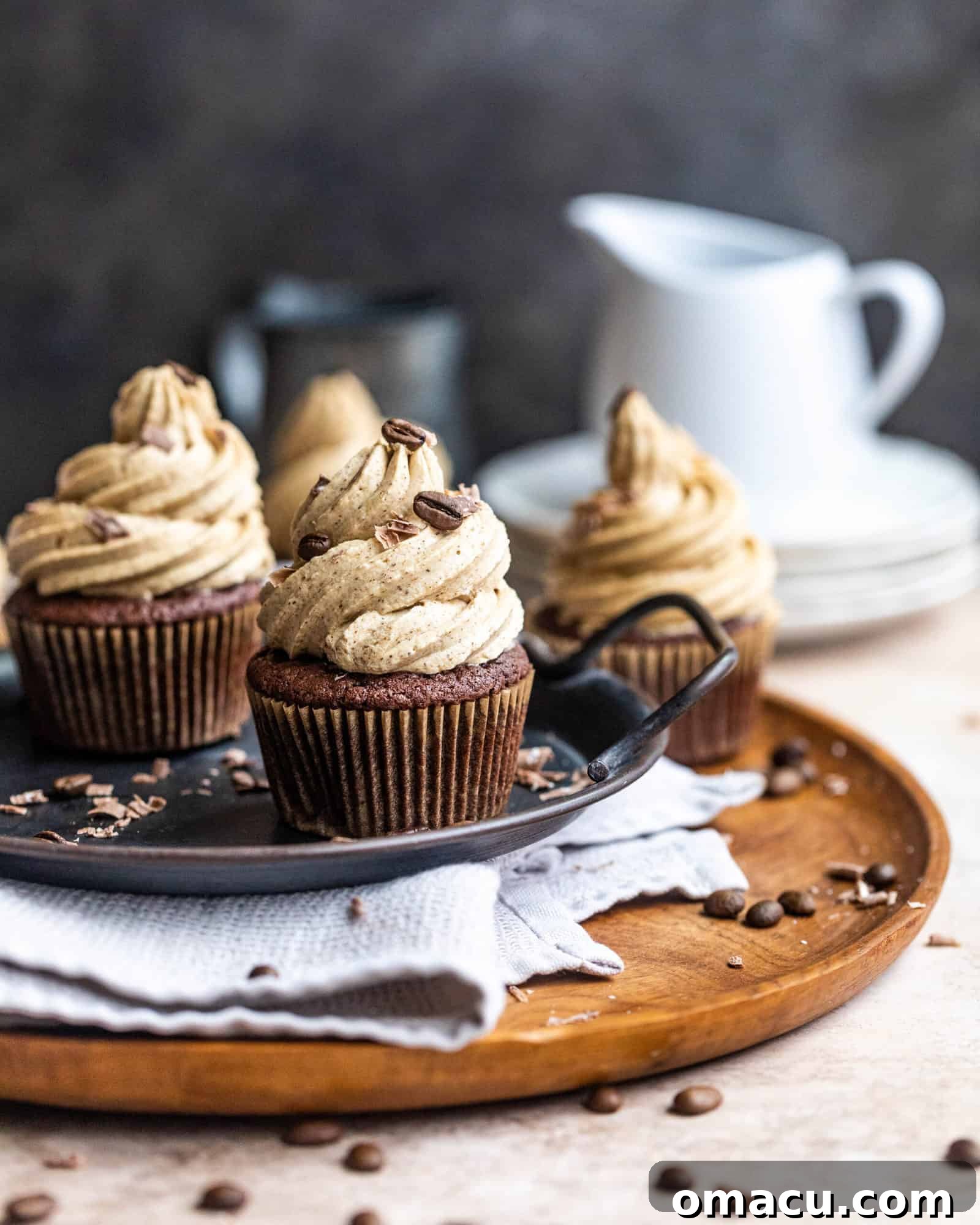 chocolate cupcakes with espresso buttercream on a serving tray, garnished with chocolate shavings