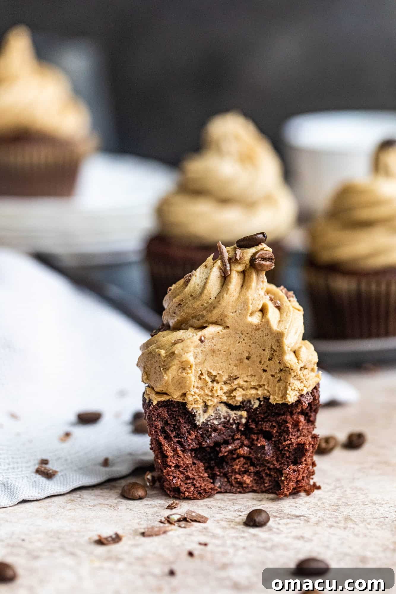 a chocolate cupcake with a bite taken out, showing the moist interior and espresso buttercream