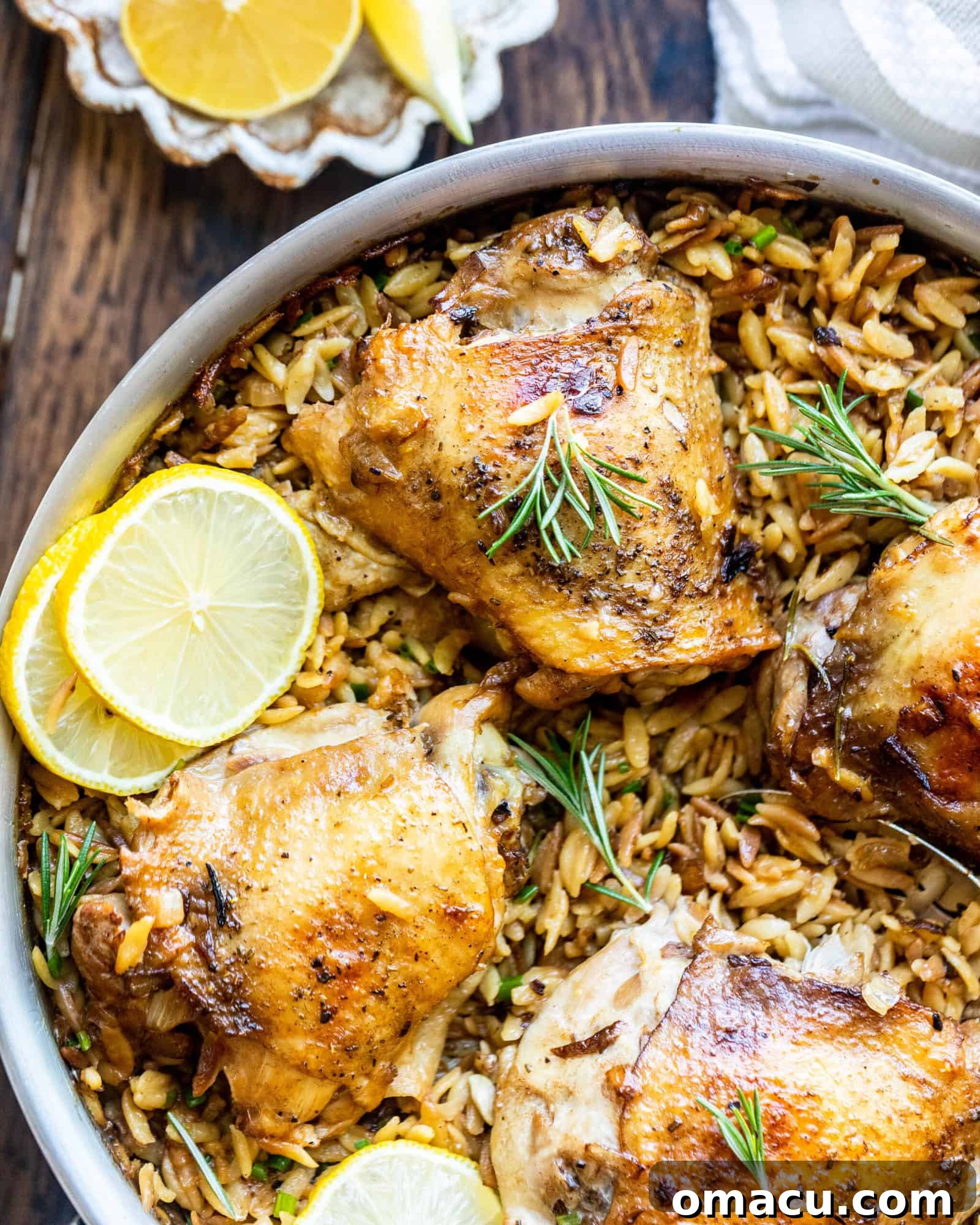 seared chicken thighs in a pan with lemons