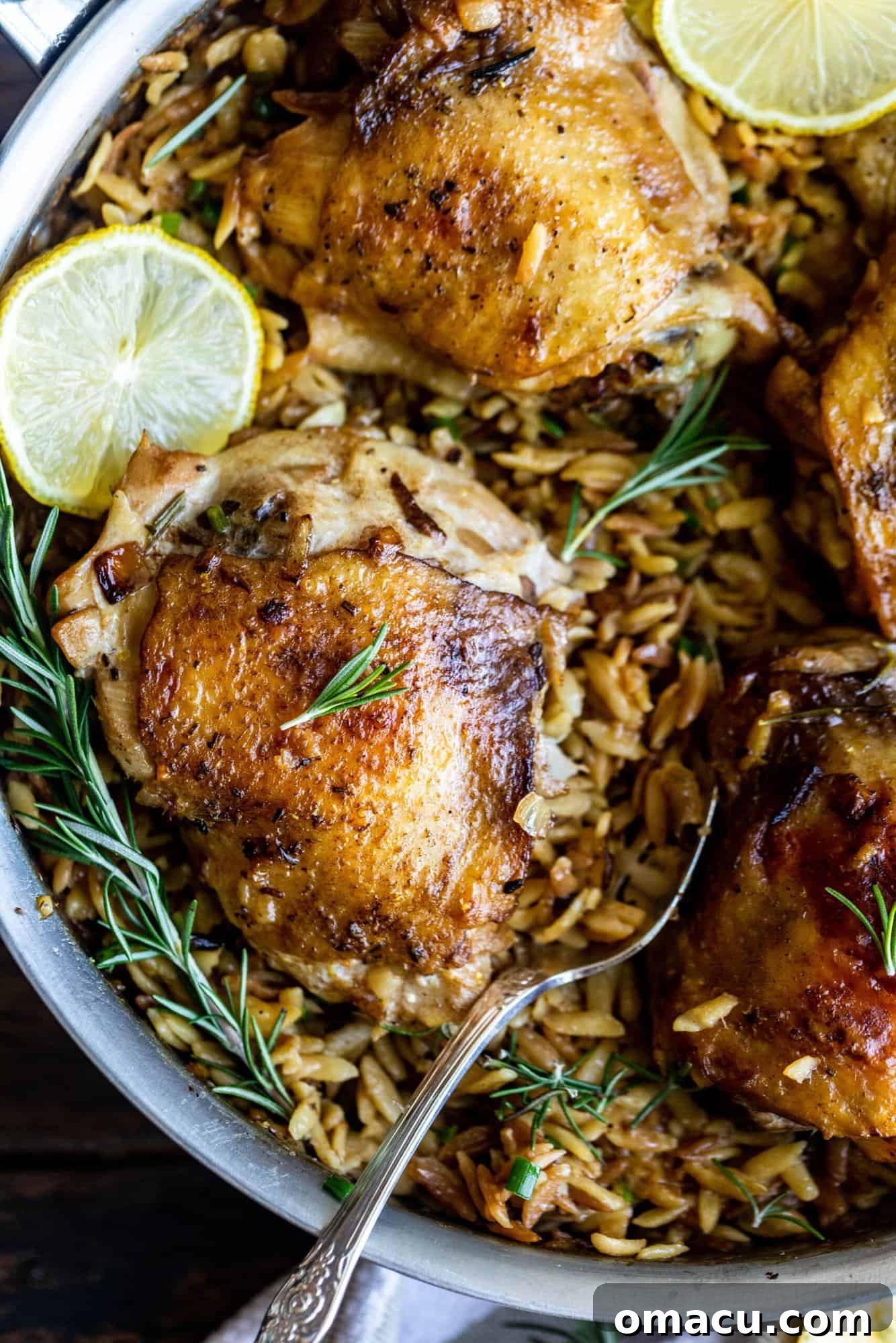 chicken and orzo in a pan with rosemary and lemon