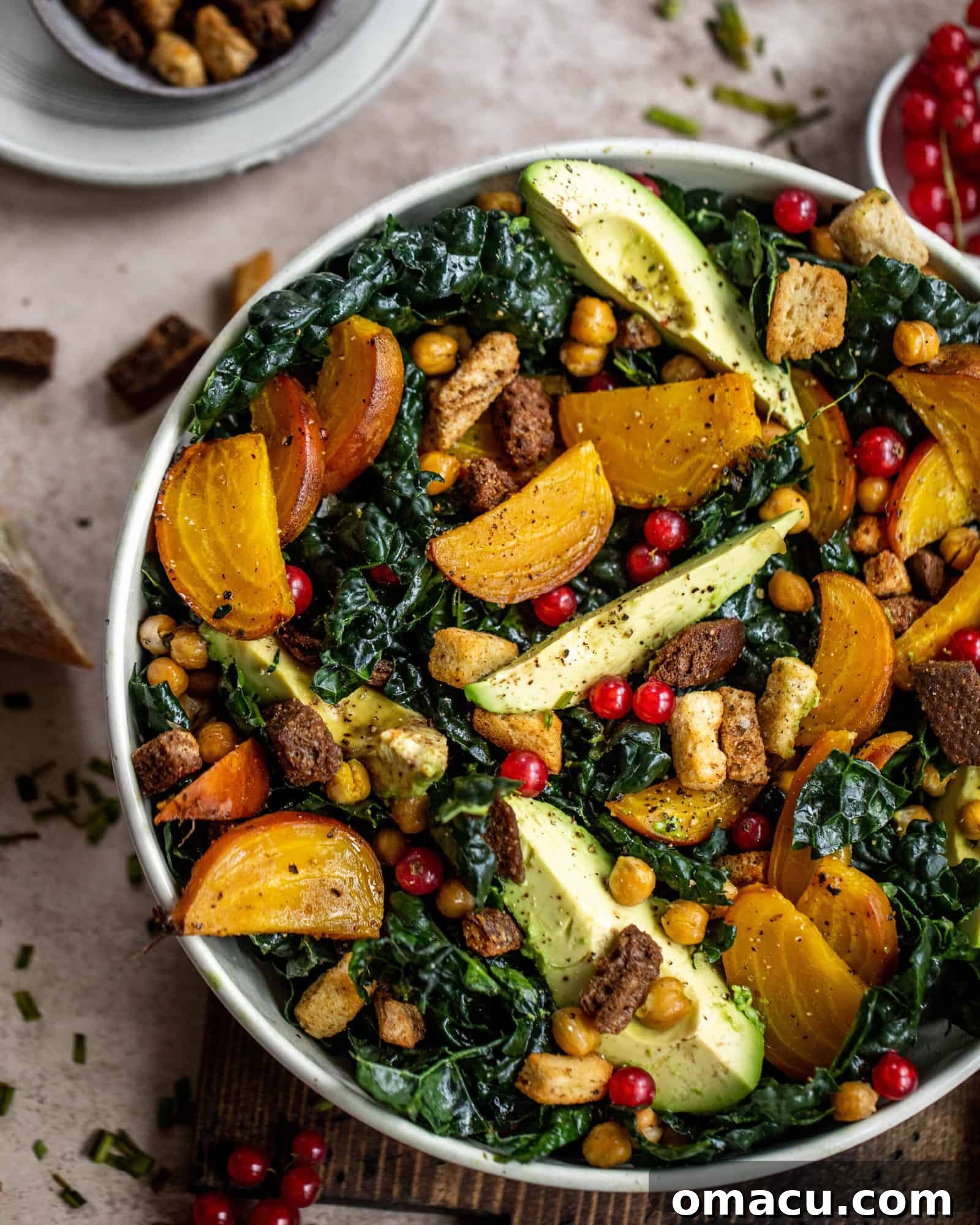 Close-up of a vibrant vegan kale caesar salad, highlighting the fresh, crisp kale, golden beets, and roasted chickpeas within a beautifully presented bowl.