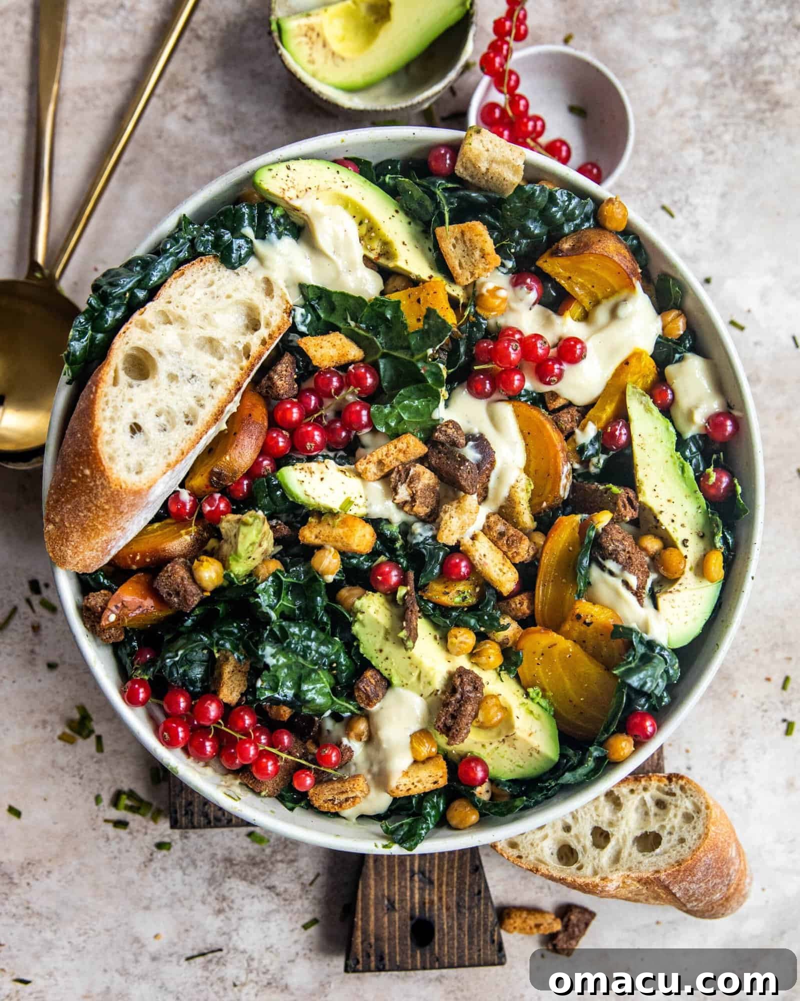 Vegan kale caesar salad in a bowl, garnished with fresh avocado slices and vibrant red currants, showcasing the beautiful and wholesome ingredients.