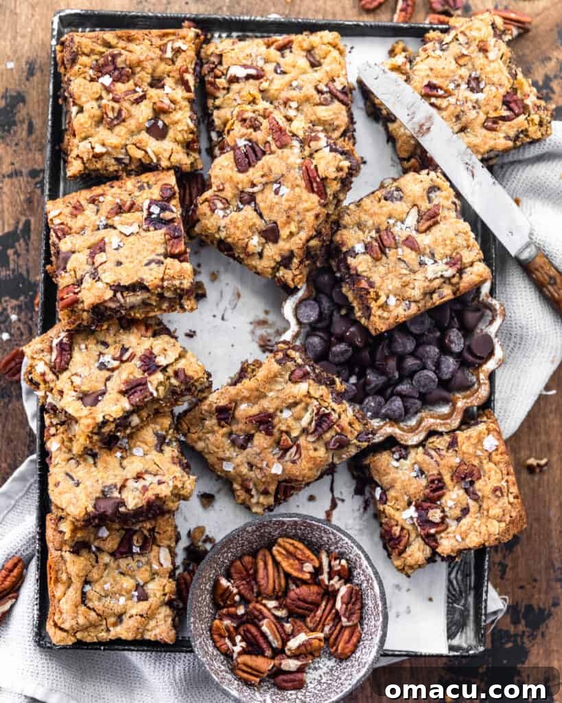 An overhead shot of an entire pan of baked chocolate chip pecan oatmeal bars, ready for slicing.