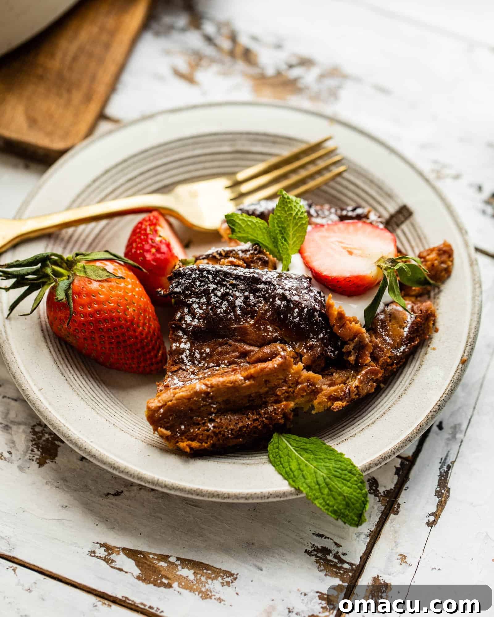 A perfectly sliced piece of Strawberry French Toast Casserole on a white plate, showcasing its fluffy texture and strawberry filling.