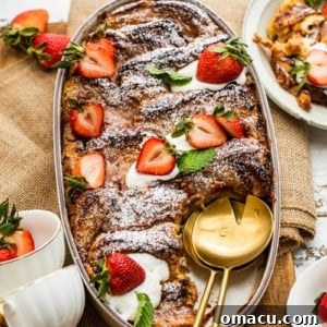 strawberry french toast casserole in a baking dish with strawberries and cream cheese