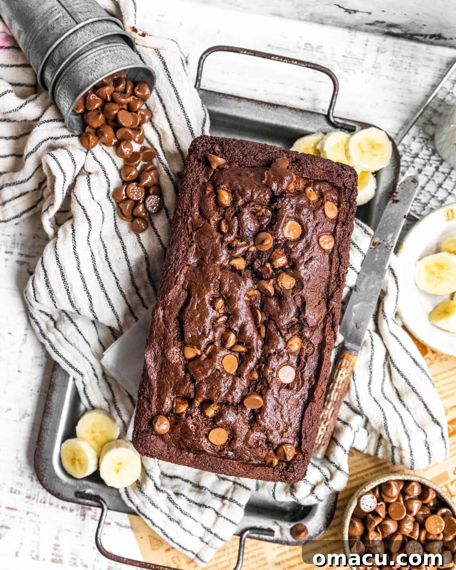 A freshly baked loaf of chocolate banana bread, still warm from the oven, cooling on a wire rack.