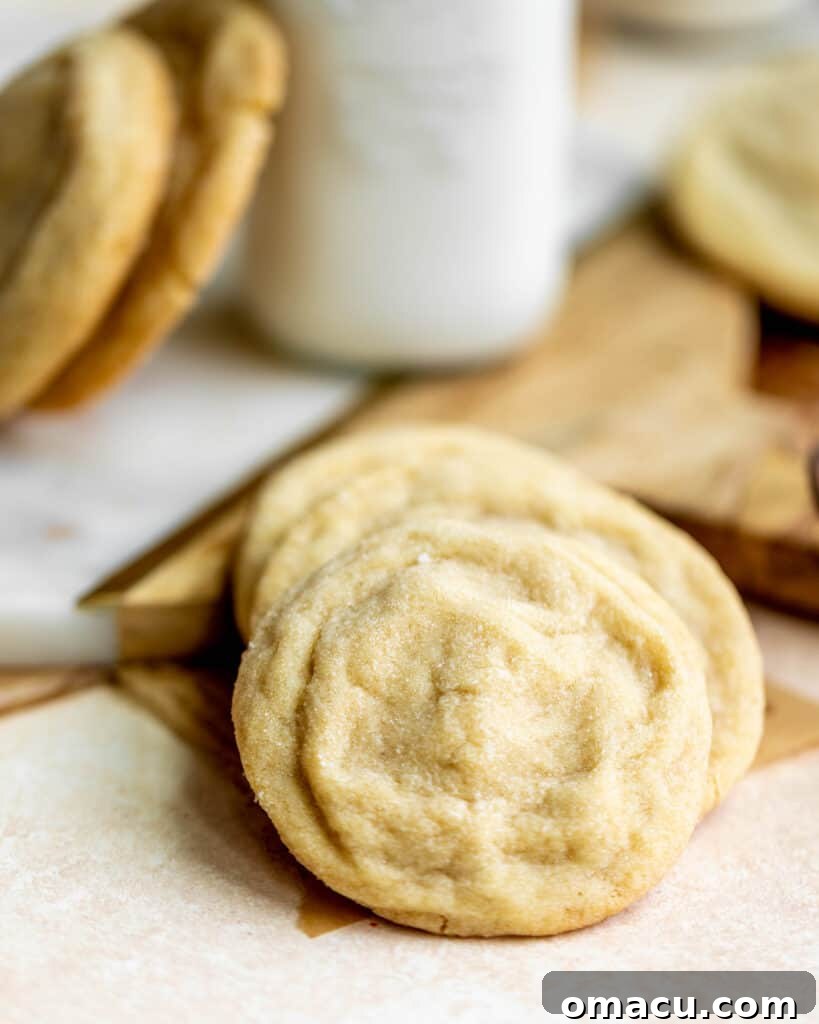 Freshly baked brown butter sugar cookies on a table with a glass of milk