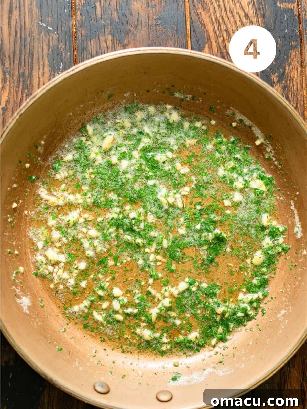 Melted butter with diced fresh garlic simmering in a small skillet.