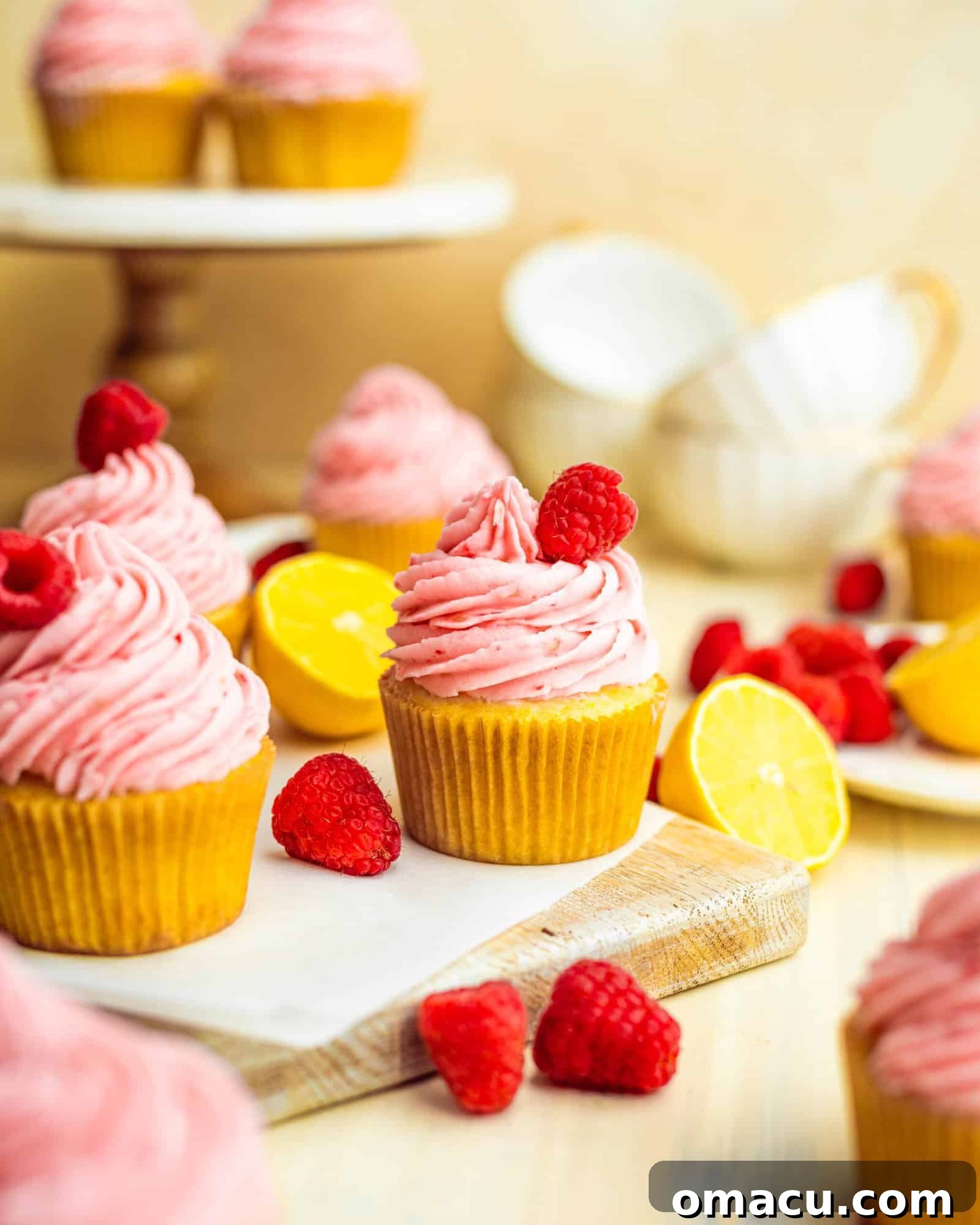 lemon cupcakes with raspberry buttercream topped with a raspberry