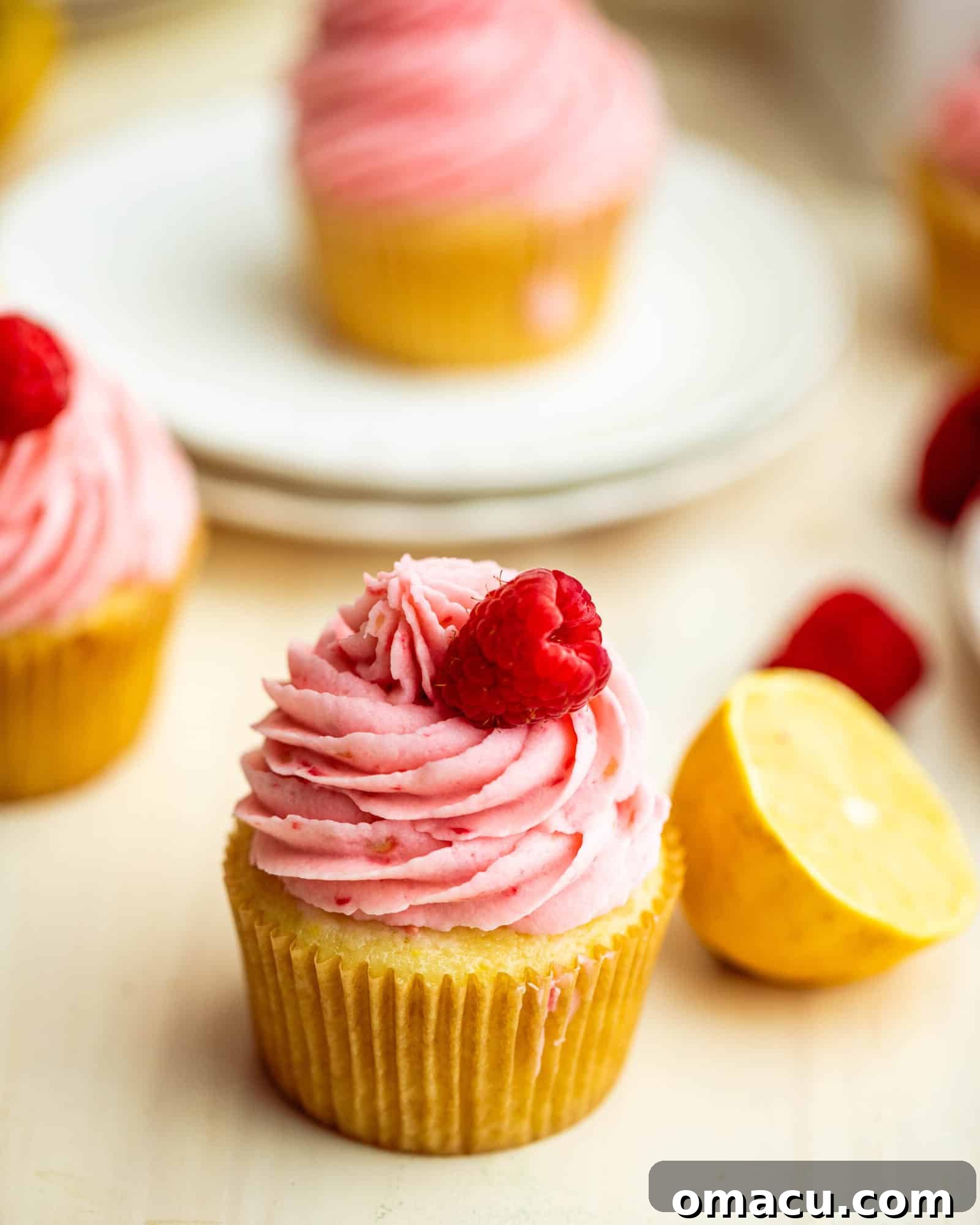 a lemon raspberry cupcake next to a lemon