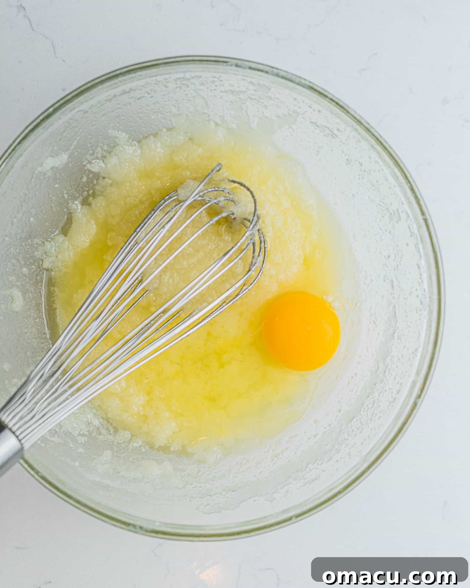 cupcake batter in a bowl with one cracked egg