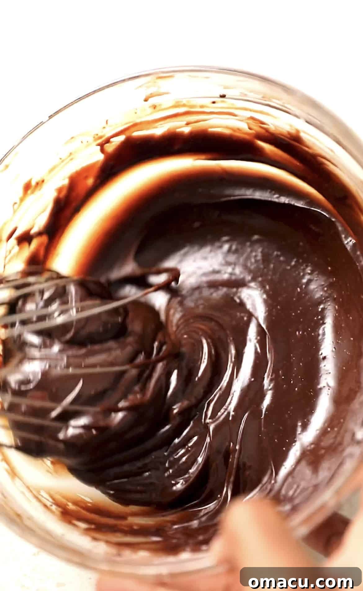 Smooth, glossy chocolate ganache in a bowl, perfectly prepared to top the cooled cosmic brownies.