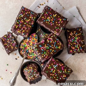 Confections on a baking pan with a spoon full of sprinkles, capturing the essence of cosmic brownies.