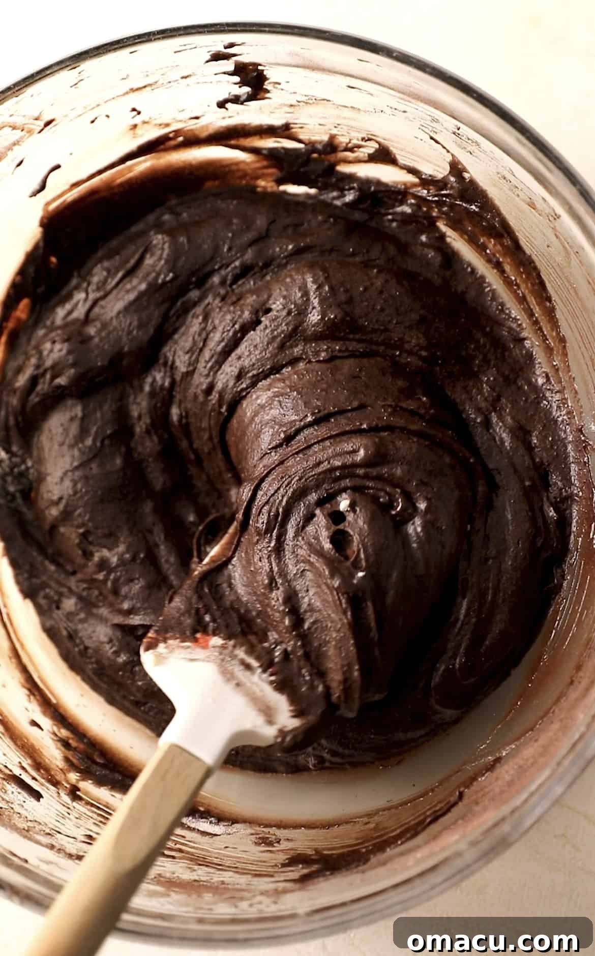 The fully mixed, rich chocolate brownie batter in a mixing bowl, ready for baking.