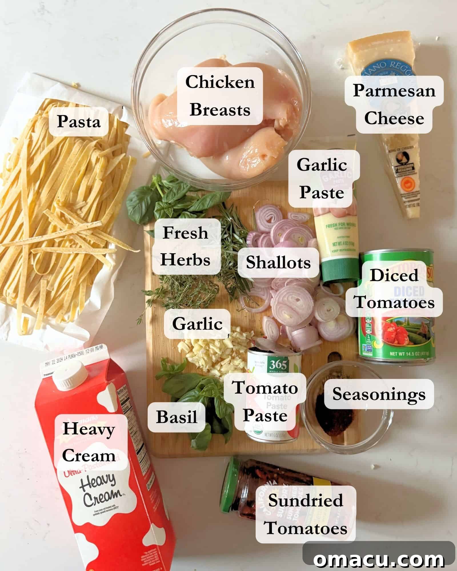 All the fresh and pantry ingredients laid out in bowls on a pristine white surface, ready to be transformed into Marry Me Chicken Pasta.