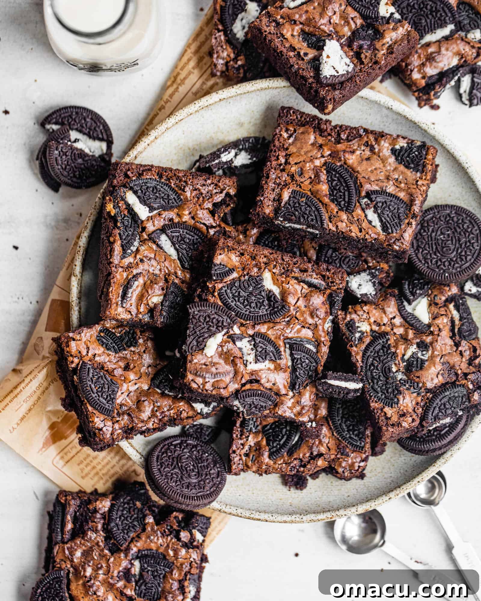 A plate filled with freshly baked Oreo brownies, neatly cut into squares, ready to be enjoyed.