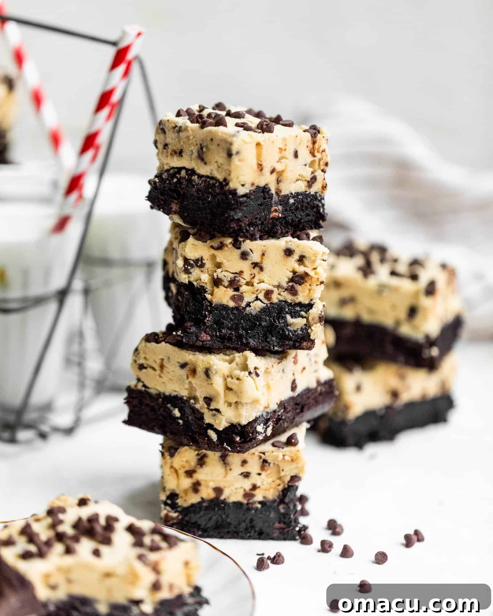 cookie dough brownies stacked on top of each other with a glass of milk