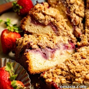 sliced strawberry crumb cake with fresh strawberries on a piece of parchment paper.