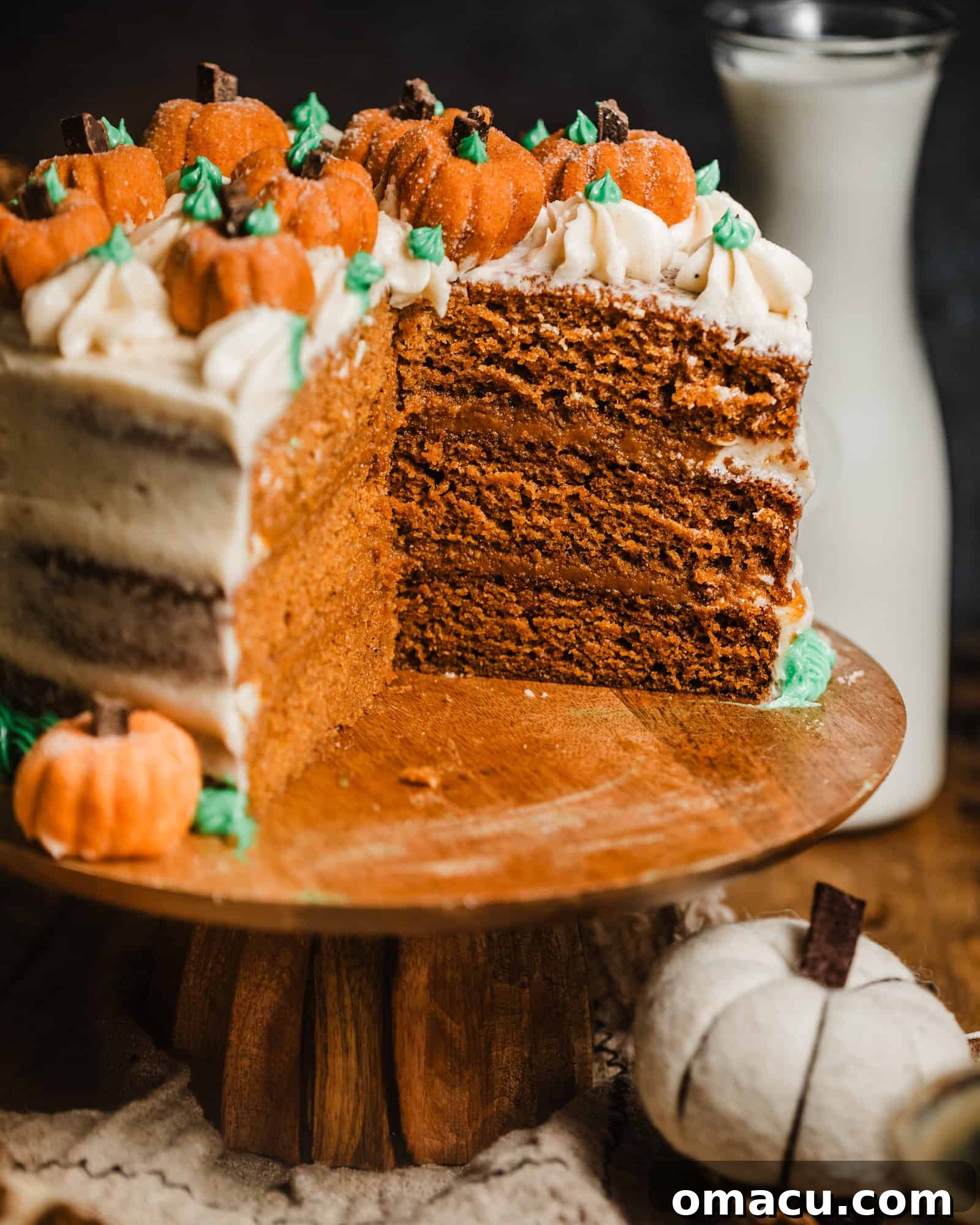 A beautifully decorated brown butter pumpkin cake on a rustic stand, ready to be served, capturing the essence of fall.