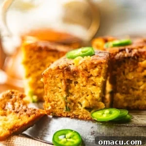 sliced jalapeno honey cornbread on a plate with spicy honey butter and jalapenos.