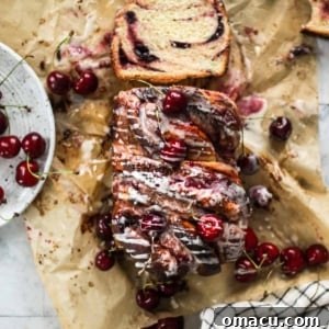 A slice of Cherry Cream Cheese Babka, showcasing the intricate swirls of dough, cherry filling, and cream cheese.