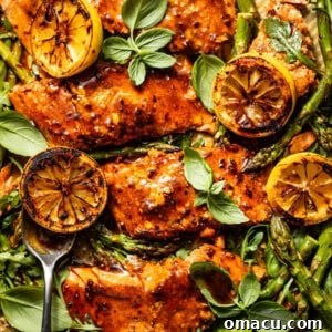 cajun salmon on a sheet pan with asparagus, charred lemons, and arugula.