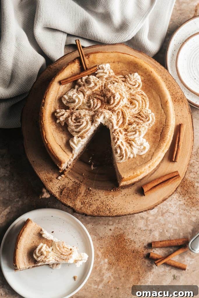 A beautifully sliced Snickerdoodle Cheesecake with a thick layer of cookie whipped cream.