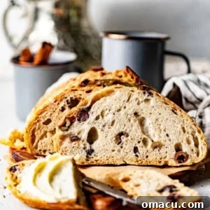 A beautiful, golden loaf of no-knead olive bread, sliced and ready to serve.