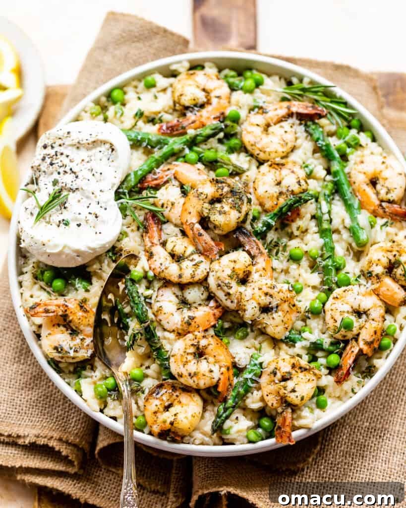 Spring Risotto topped with garlic butter shrimp in a large serving bowl