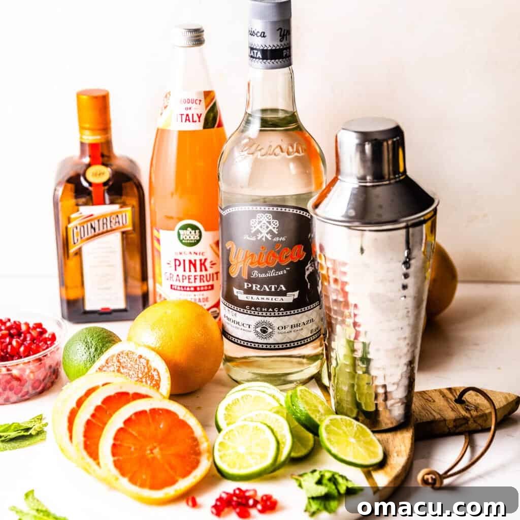 ingredients to make grapefruit margaritas - limes, grapefruit, tequila, triple sec, and a shaker cup