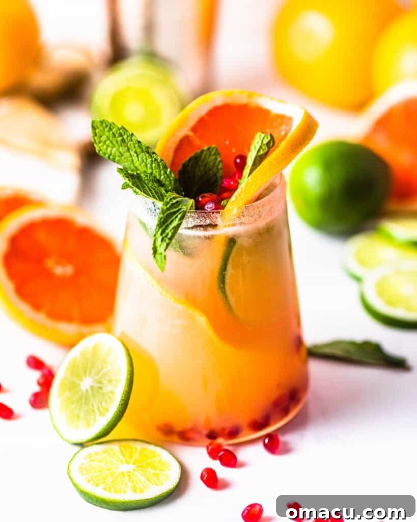 grapefruit and limes on a serving board with a glass of grapefruit margaritas