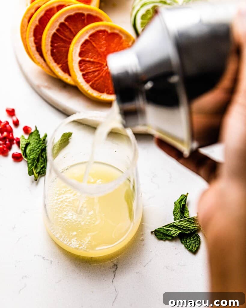 pouring tequila, lime juice, and cointreau into a glass from a shaker cup