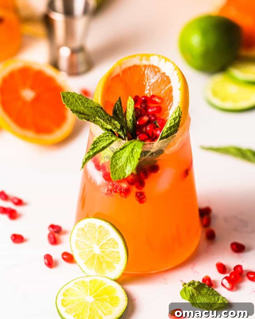 grapefruit and limes in a glass with pomegranate arils and mint leaves