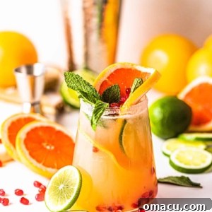 grapefruit margaritas in a glass with sliced limes and pink grapefruit