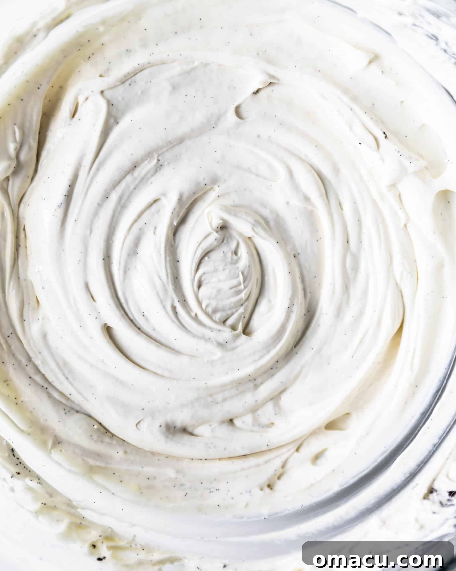 Fluffy whipped mascarpone frosting in a large mixing bowl, showcasing its creamy texture.