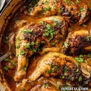 A close-up of beautifully baked chicken leg quarters in a skillet, golden and juicy.