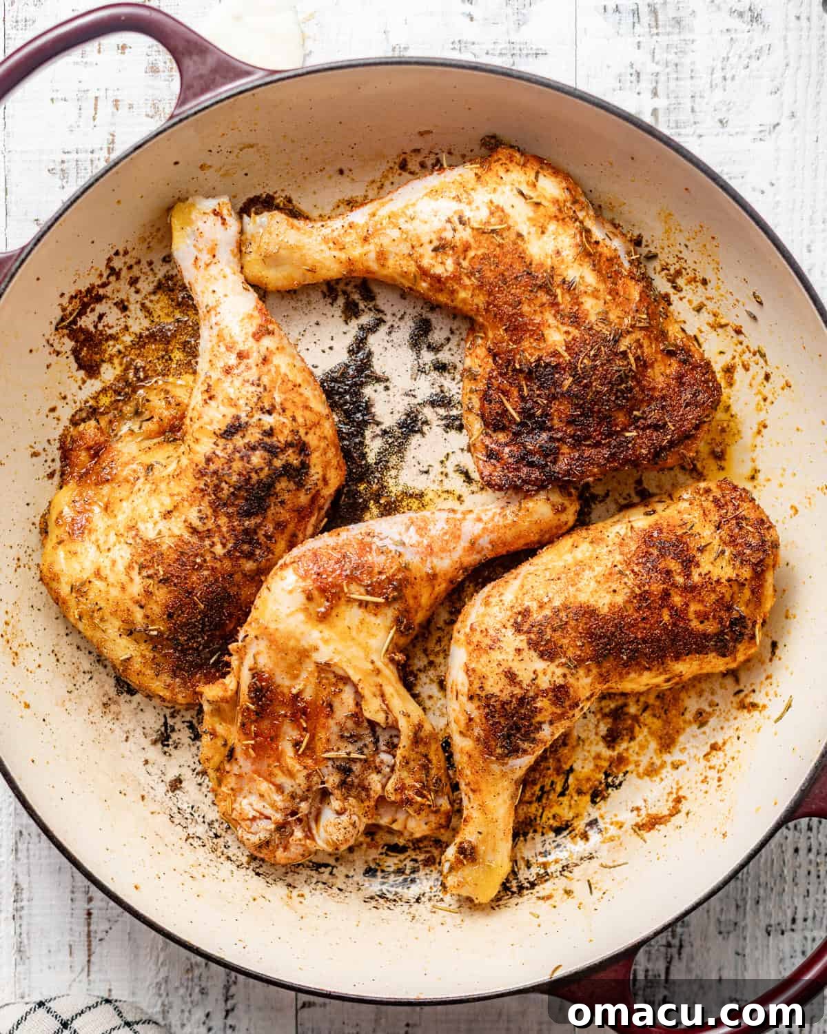 Chicken leg quarters searing to a perfect golden-brown in a hot cast iron skillet.