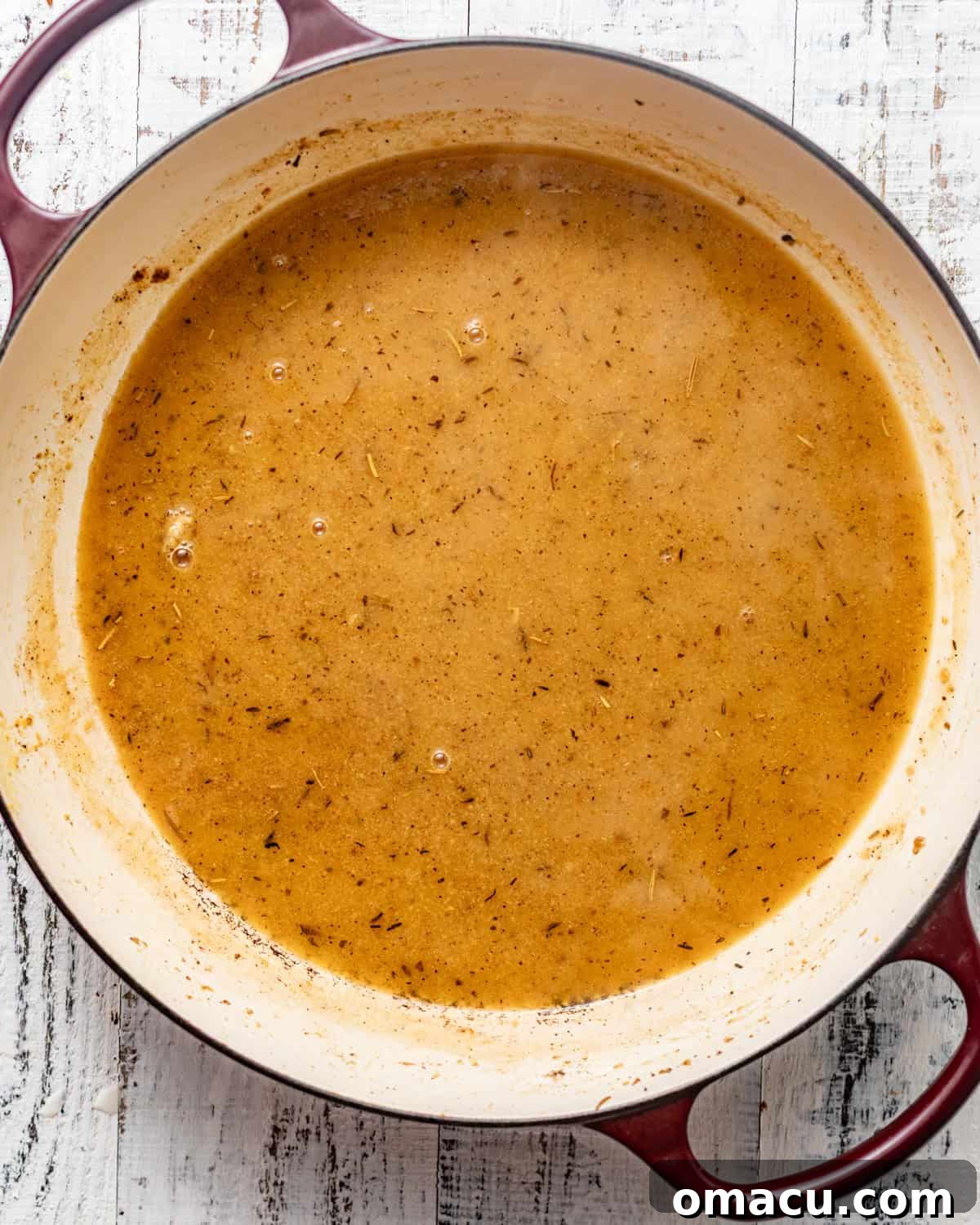 The savory pan sauce being whisked together in the skillet, incorporating all the browned bits.