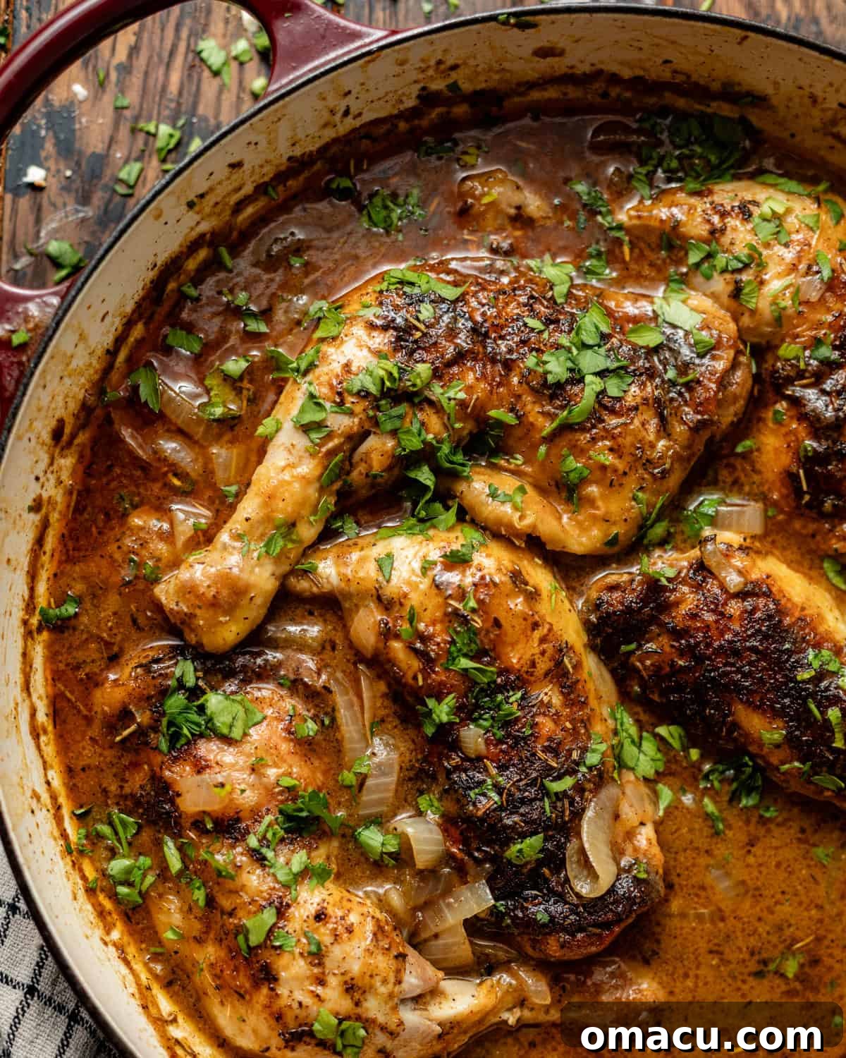 Baked chicken leg quarters garnished with fresh parsley in a skillet, ready to be served alongside complementary side dishes.