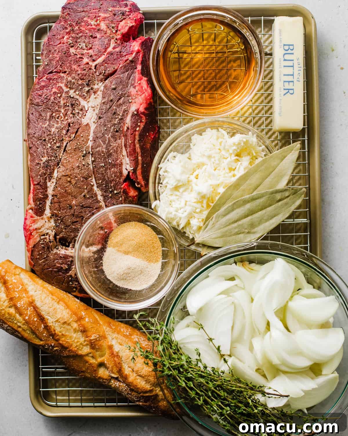 ingredients to make french onion pot roast -  chuck roast, onions, thyme, whiskey, red wine,  baguette, butter, gruyere cheese, beef bouillon paste, tomato paste, and garlic. 
