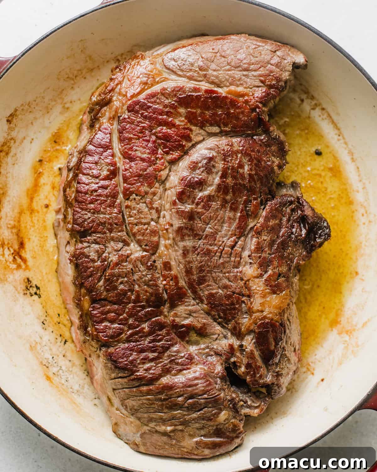 seared chuck roast in a braising pan. 