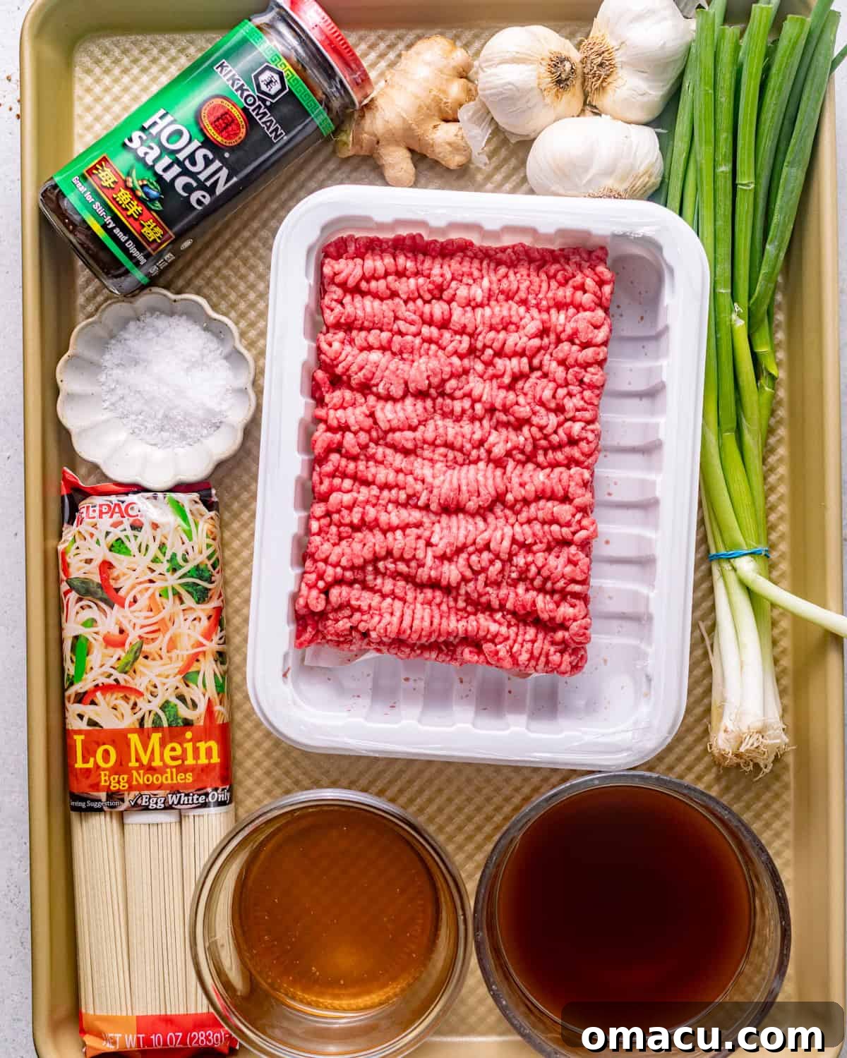 ingredients to make mongolian ground beef noodles - ground beef, hoisin sauce, lo mein noodles, scallions, beef broth, honey, soy sauce, garlic, salt, and fresh ginger.