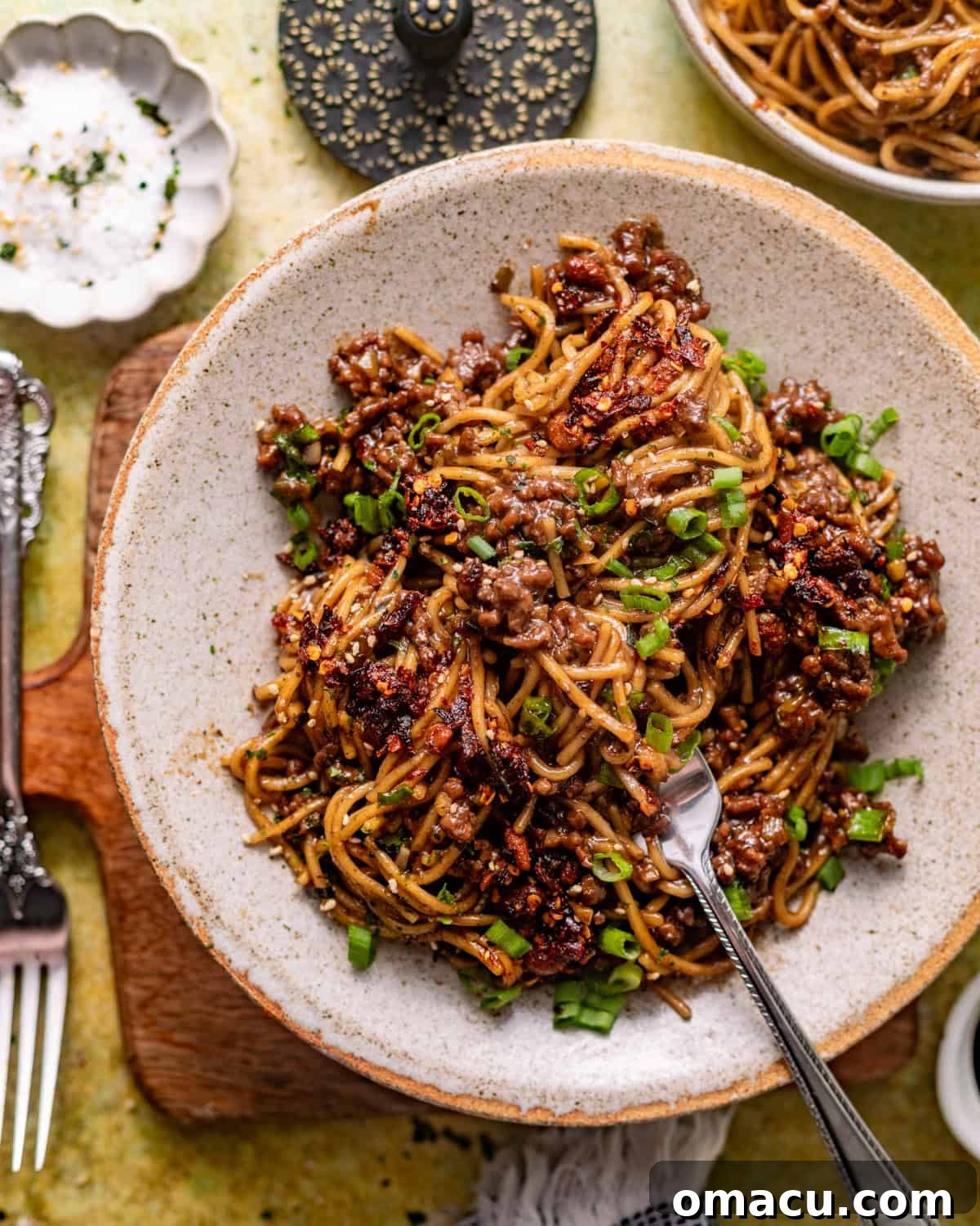 overhead photo of mongolian ground beef noodles in a bowl with a fork.