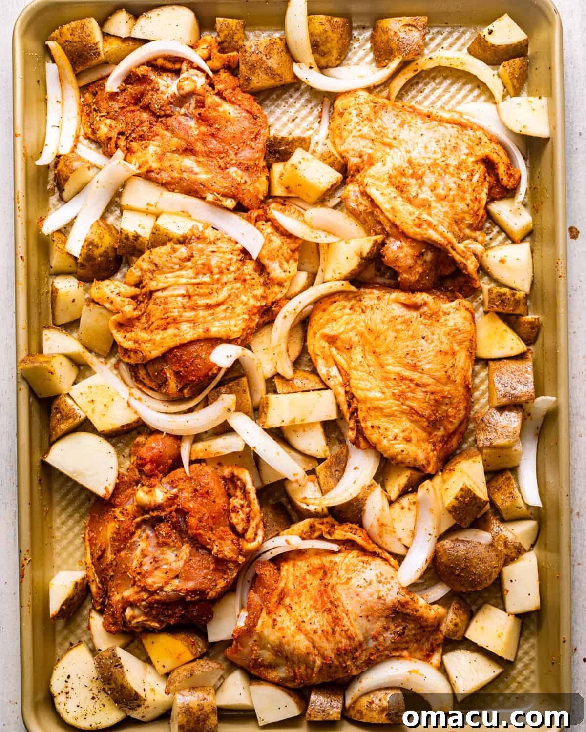 chicken, potatoes, and onions on a sheet pan. 