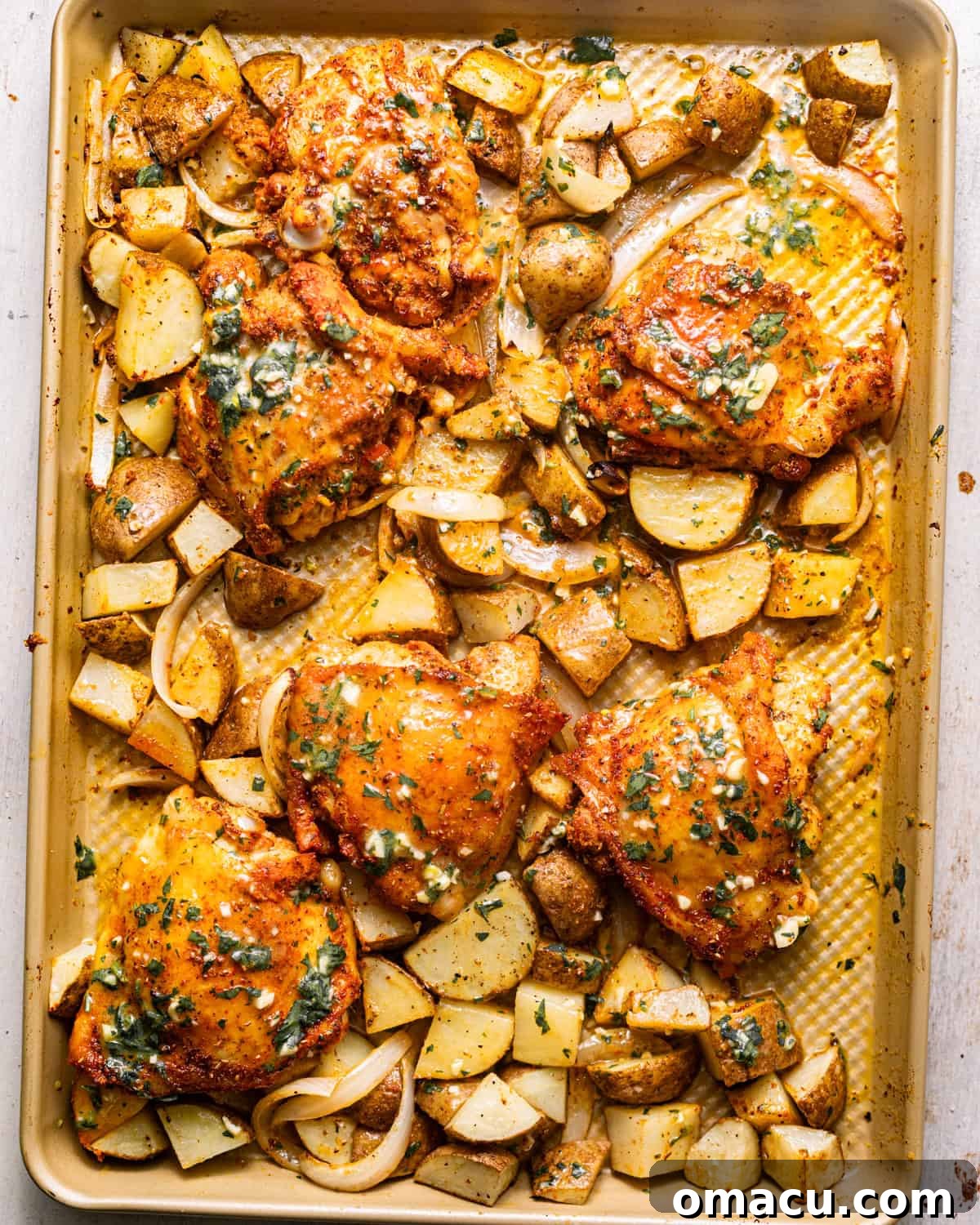 chicken thighs, potatoes, and onions covered in a lemon and garlic dijon dressing.