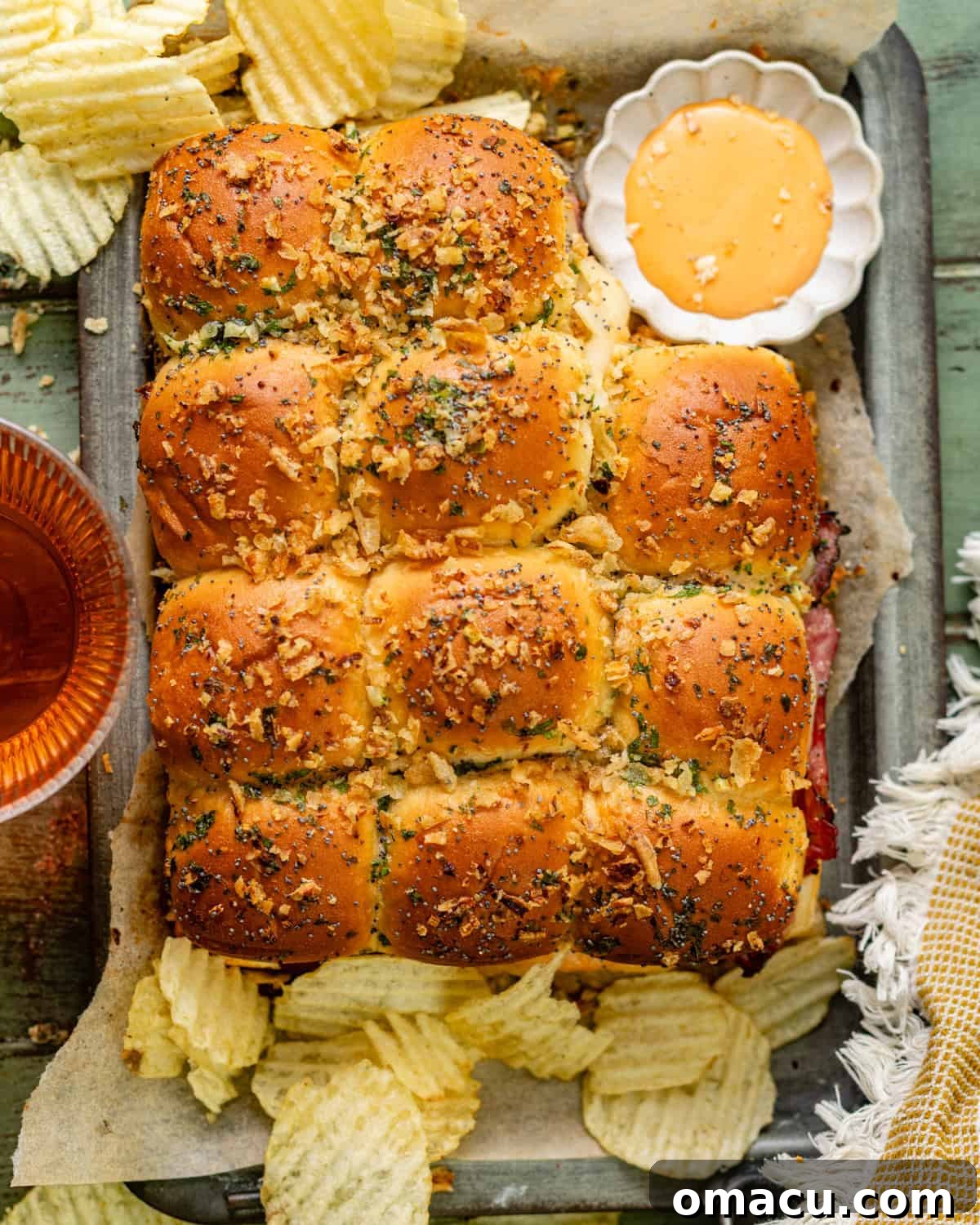 An inviting overhead photo of freshly baked Reuben sliders artfully arranged on a serving tray, their golden-brown buns and melted cheese gleaming, ready to be enjoyed.