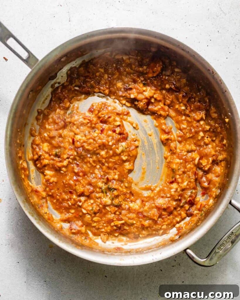 Sautéed shallots and garlic in a pan, with Cognac being added to build the creamy pan sauce.