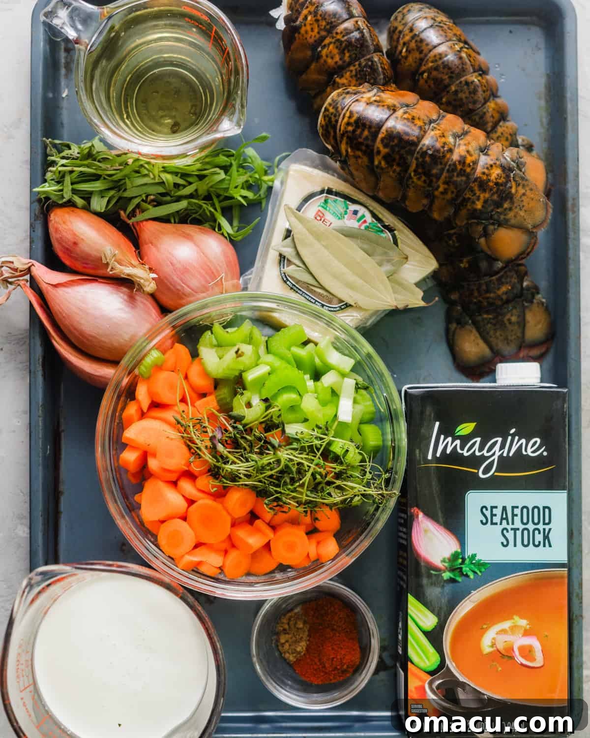 A curated selection of fresh ingredients for lobster bisque, including vibrant lobster tails, crisp carrots and celery, aromatic shallots, fresh herbs, and essential liquids like seafood stock, heavy cream, white wine, and brandy.