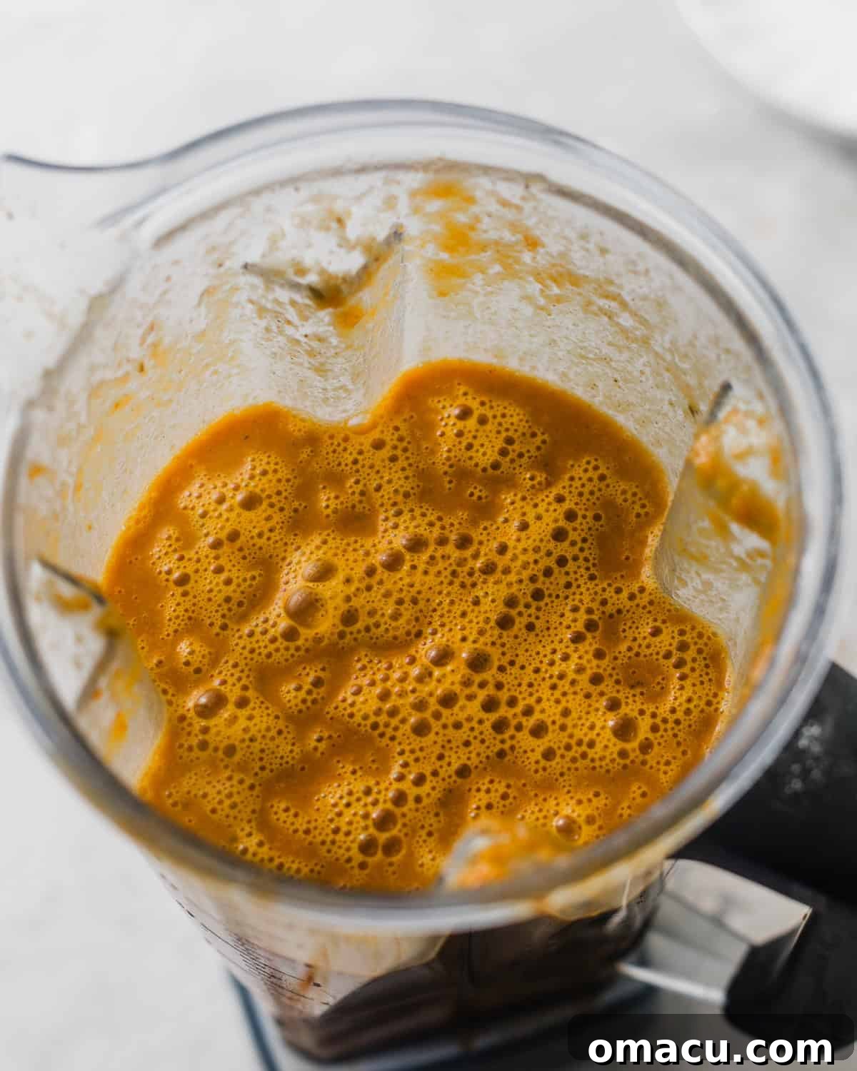 The blended bisque base, now smooth and vibrant, ready to be strained back into the pot.