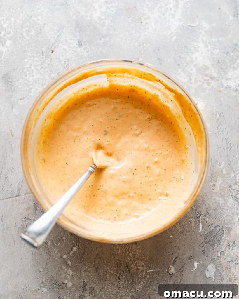 All ingredients for the remoulade sauce are mixed together in a bowl, showing its creamy texture.